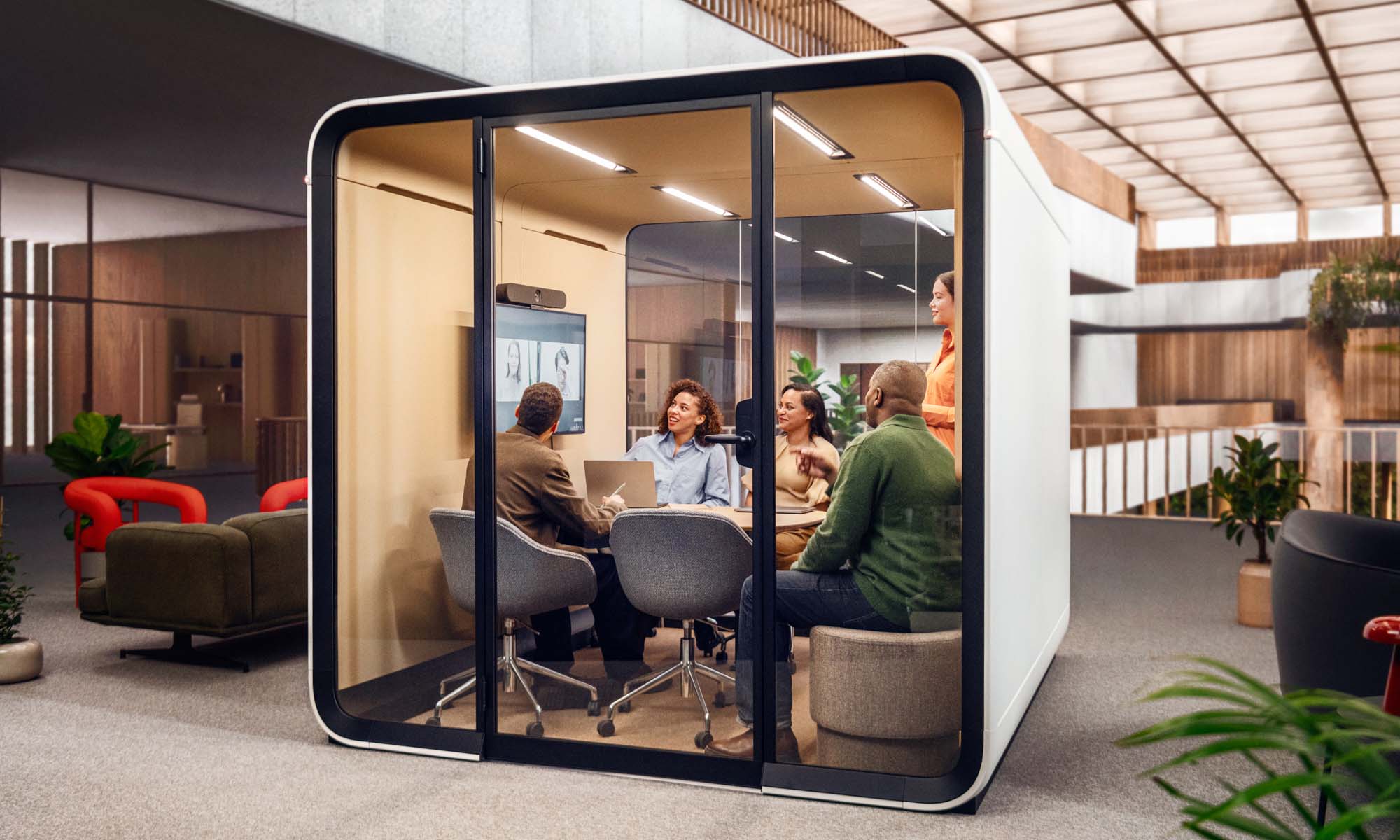 People in a hybrid meeting inside a Framery Six meeting room.