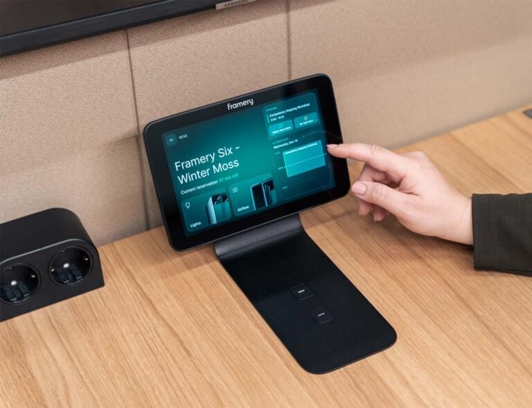 A person adjusting the meeting reservation using the touch screen panel inside a Framery pod.