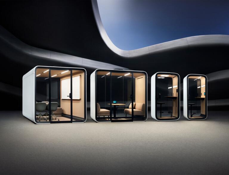 Four Framery smart pods with minimalist interiors are set against a dynamic, undulating black ceiling. Each pod offers a different seating arrangement.