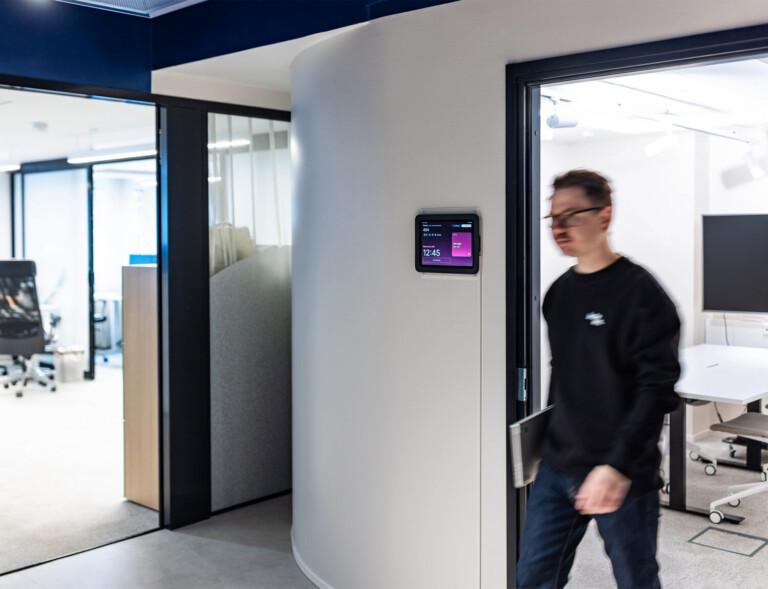 Man walking out of a meeting room in an office.