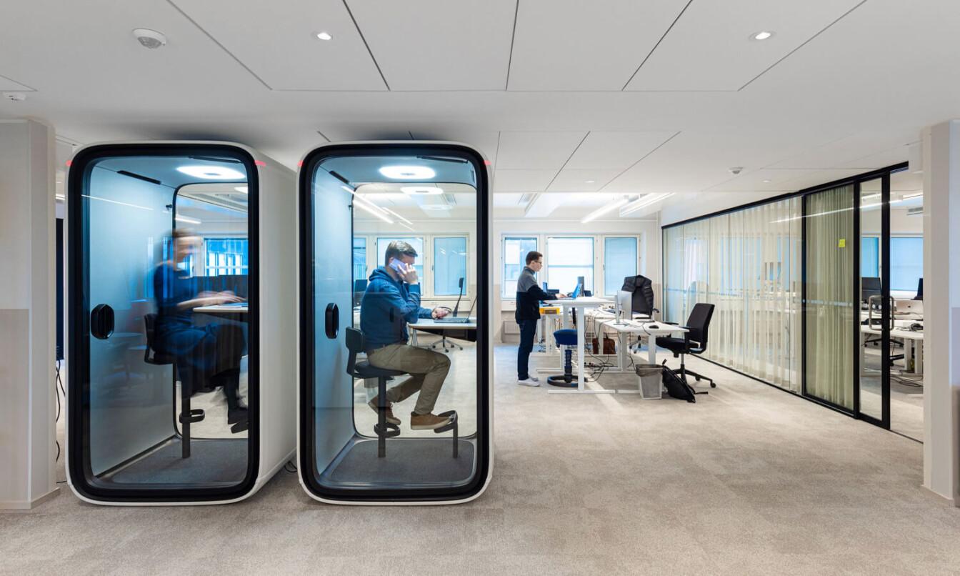 Two white Framery One office pods inside an office.