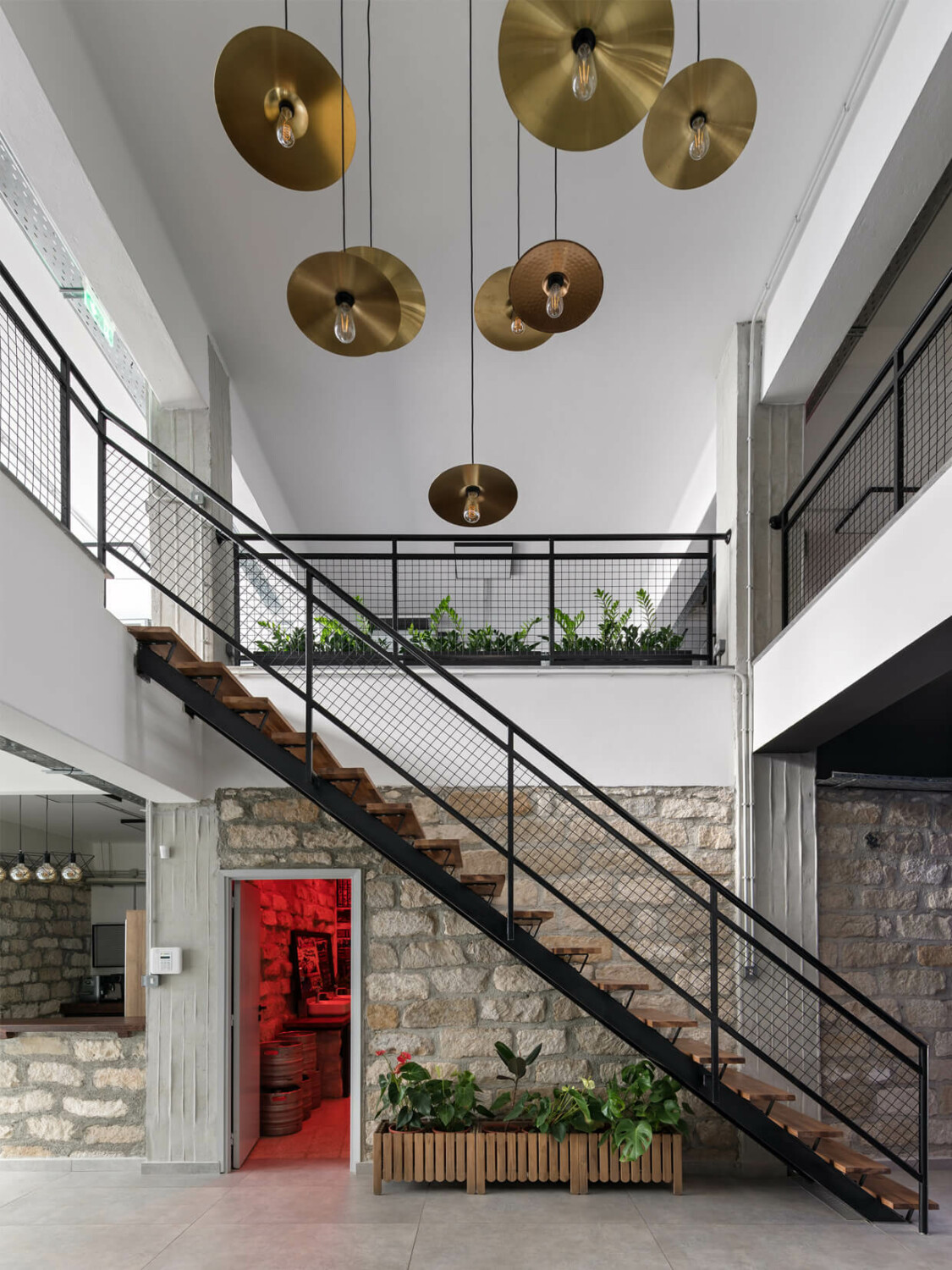 Office hallway staircase with a modern look and snare drum plates hanging from the ceiling.