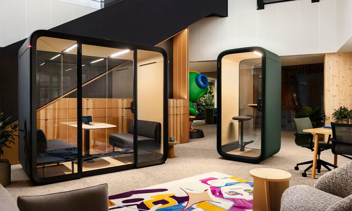 Framery Four meeting pod and Framery One Compact smart pod in a modern, colorful multifunctional office space.