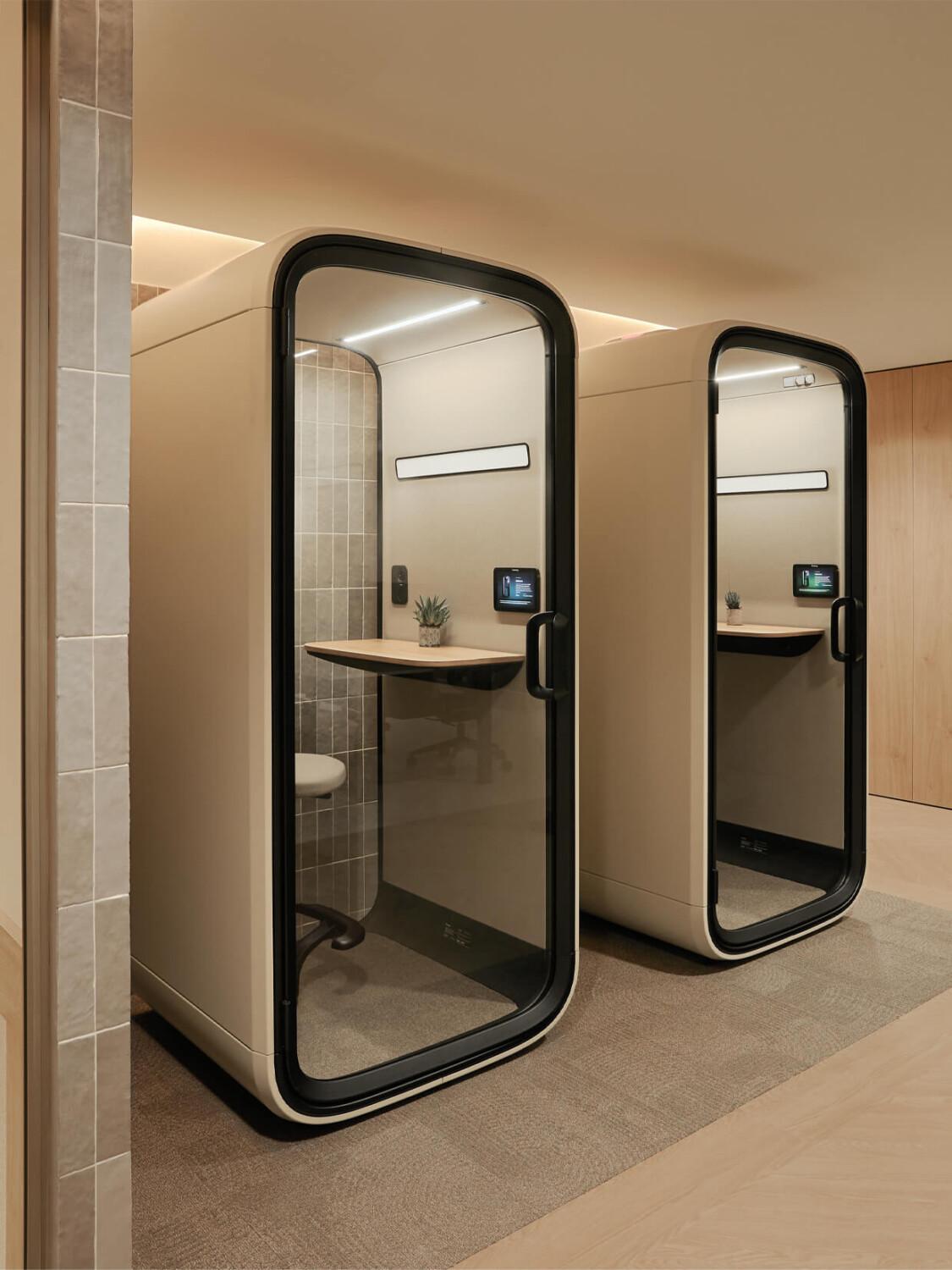 Two sand colored office phone booths.