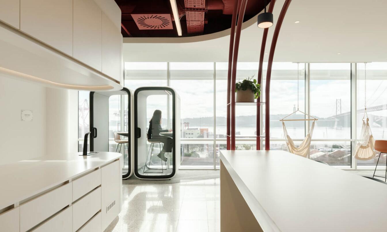 A white office kitchen with Framery One office pod at the back.