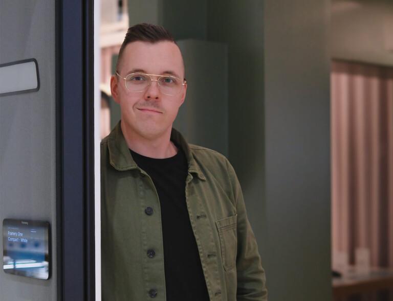 A man leaning against an office pod.