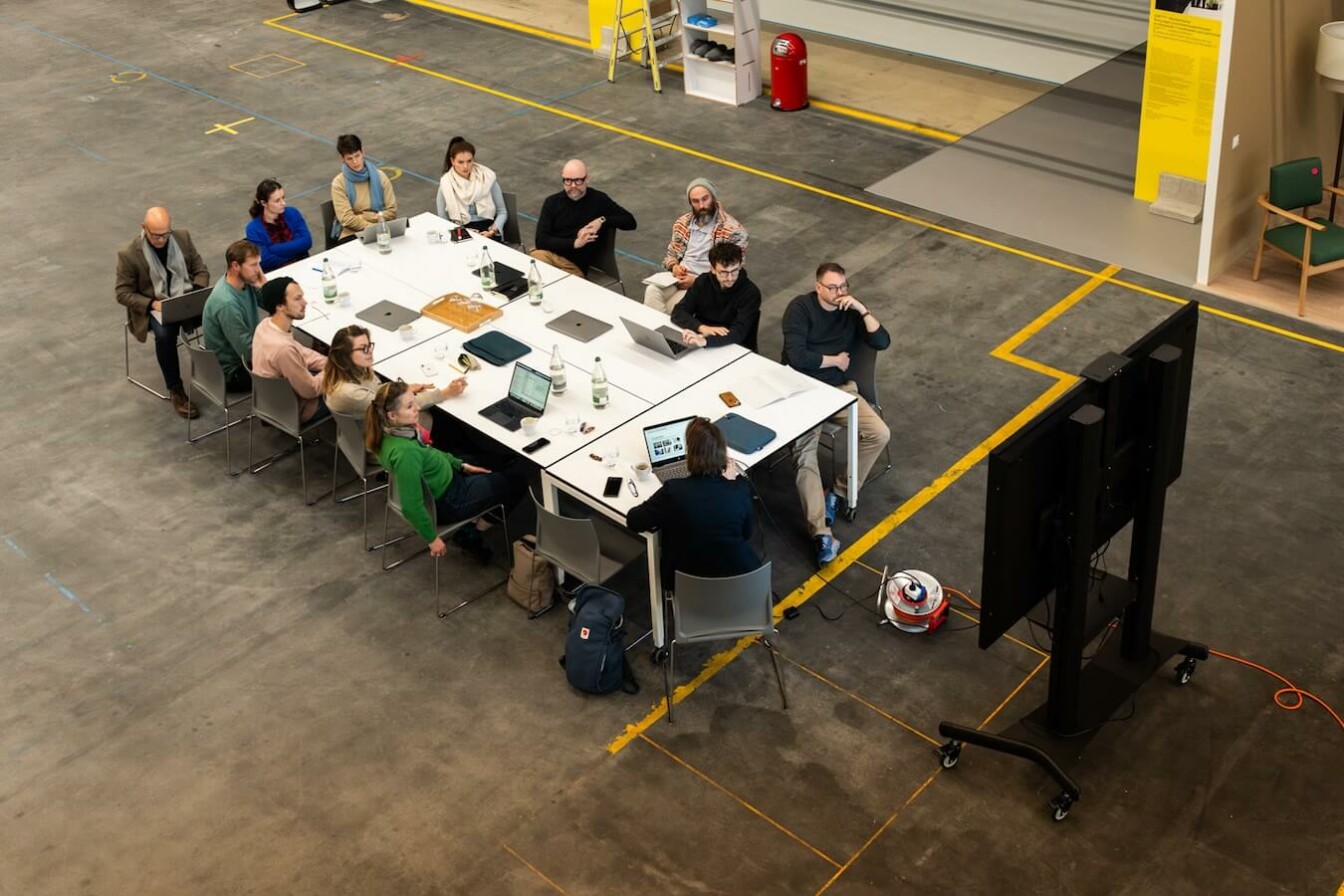 People workshopping around a long white table.